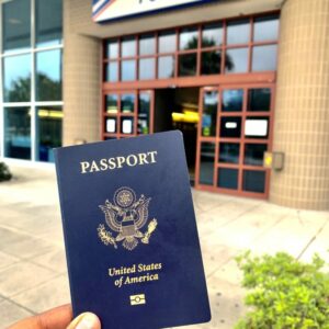 A picture of a U.S. passport being held in front of the post office. 