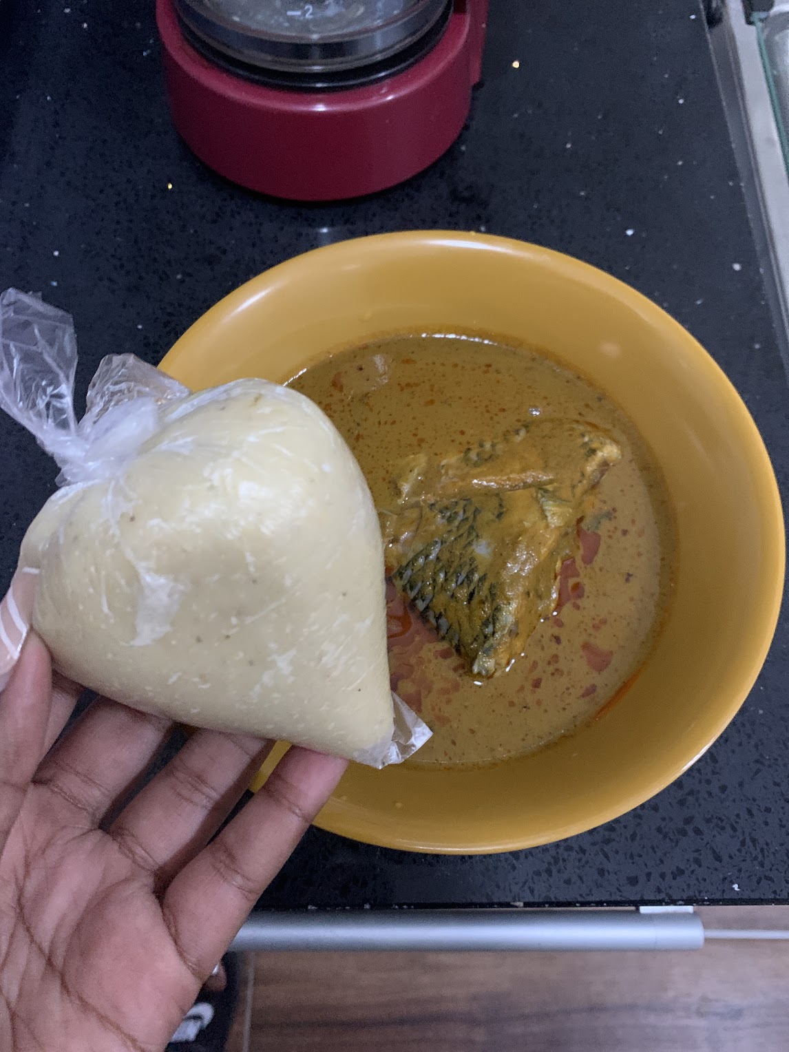 A bowl of groundnut soup with banku. 