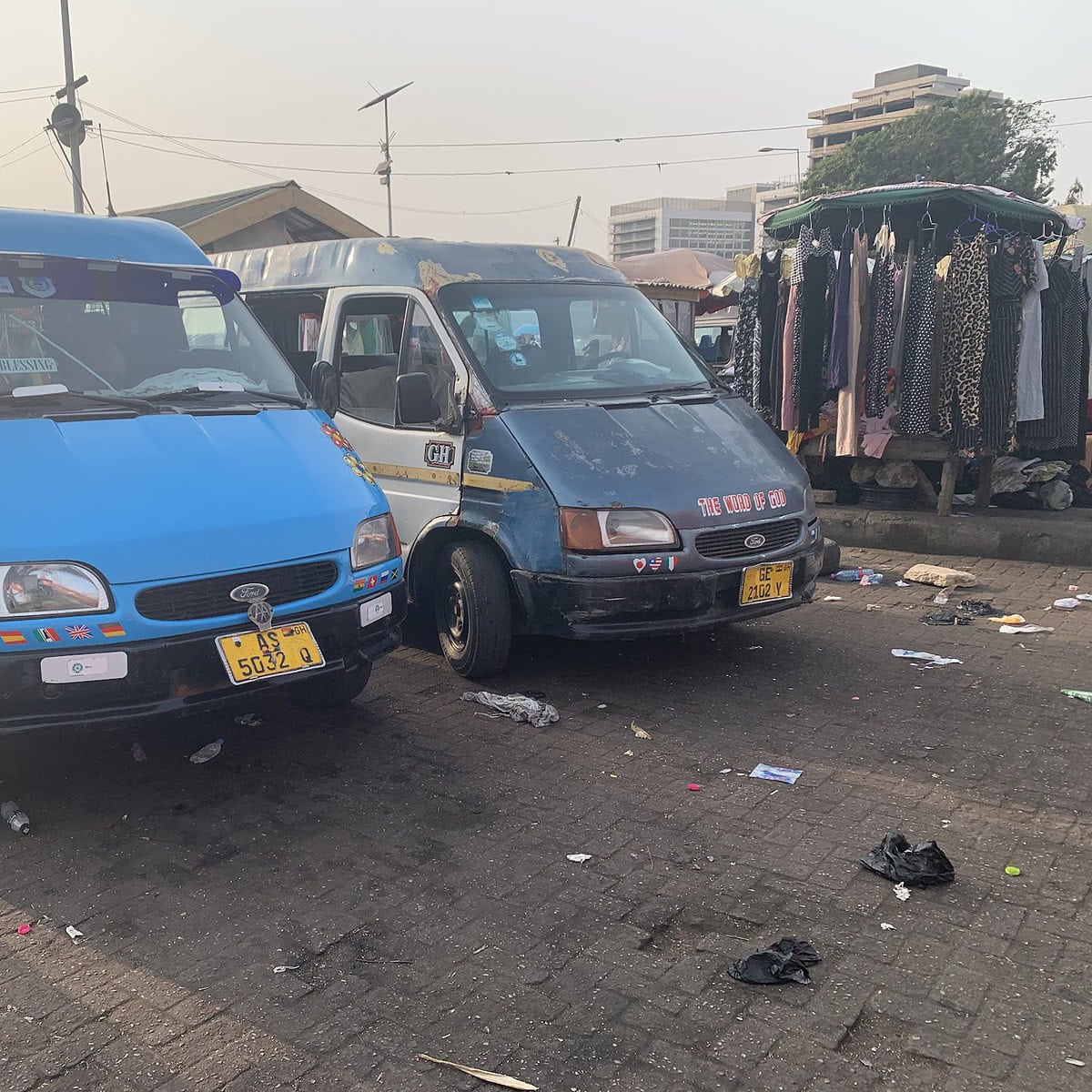 Two tro-tros in Ghana alongside each other at a stop waiting to accept passengers.