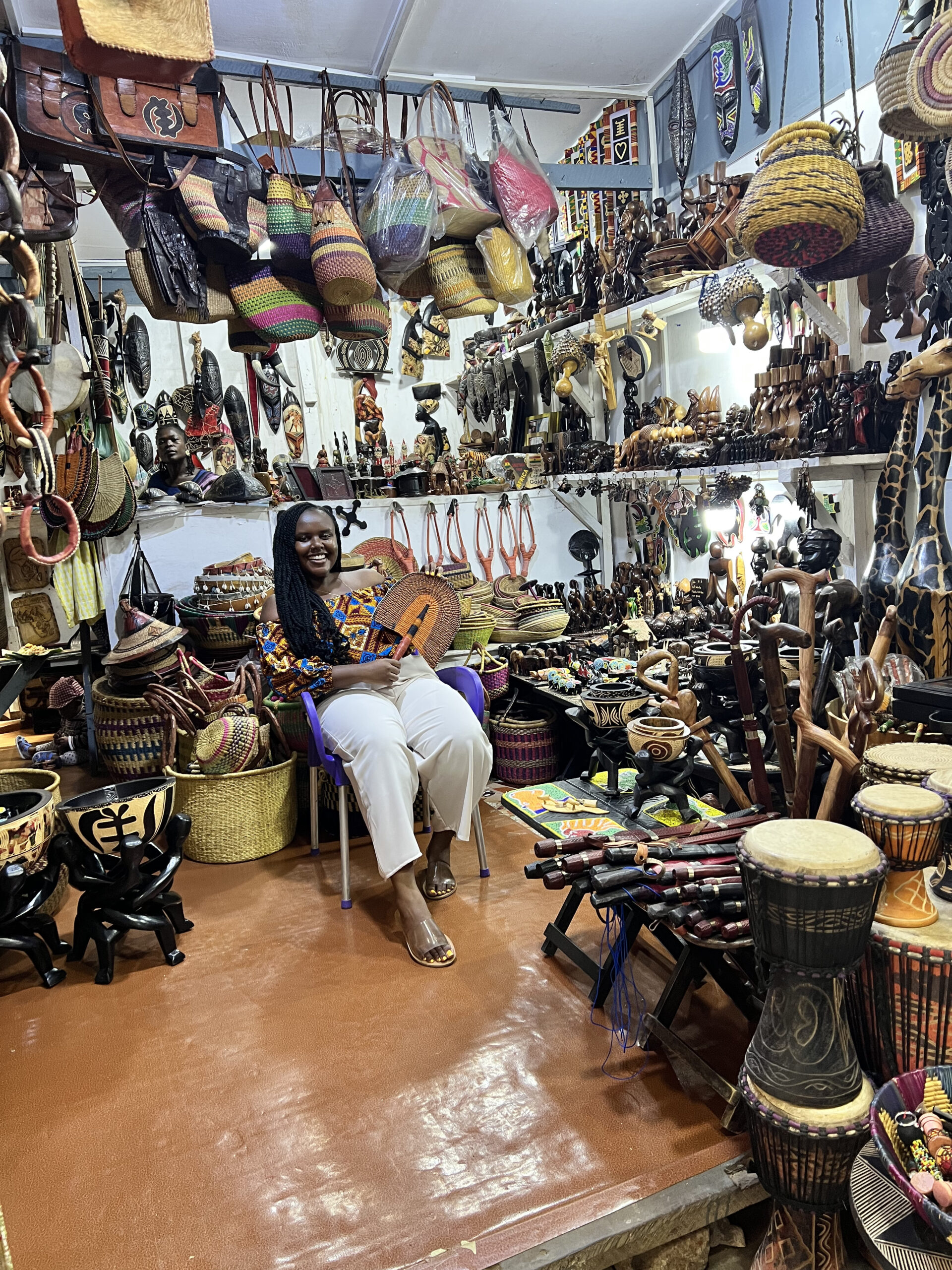Blogger Christina Jane sitting in a shop at the Arts Center around many souvenirs.