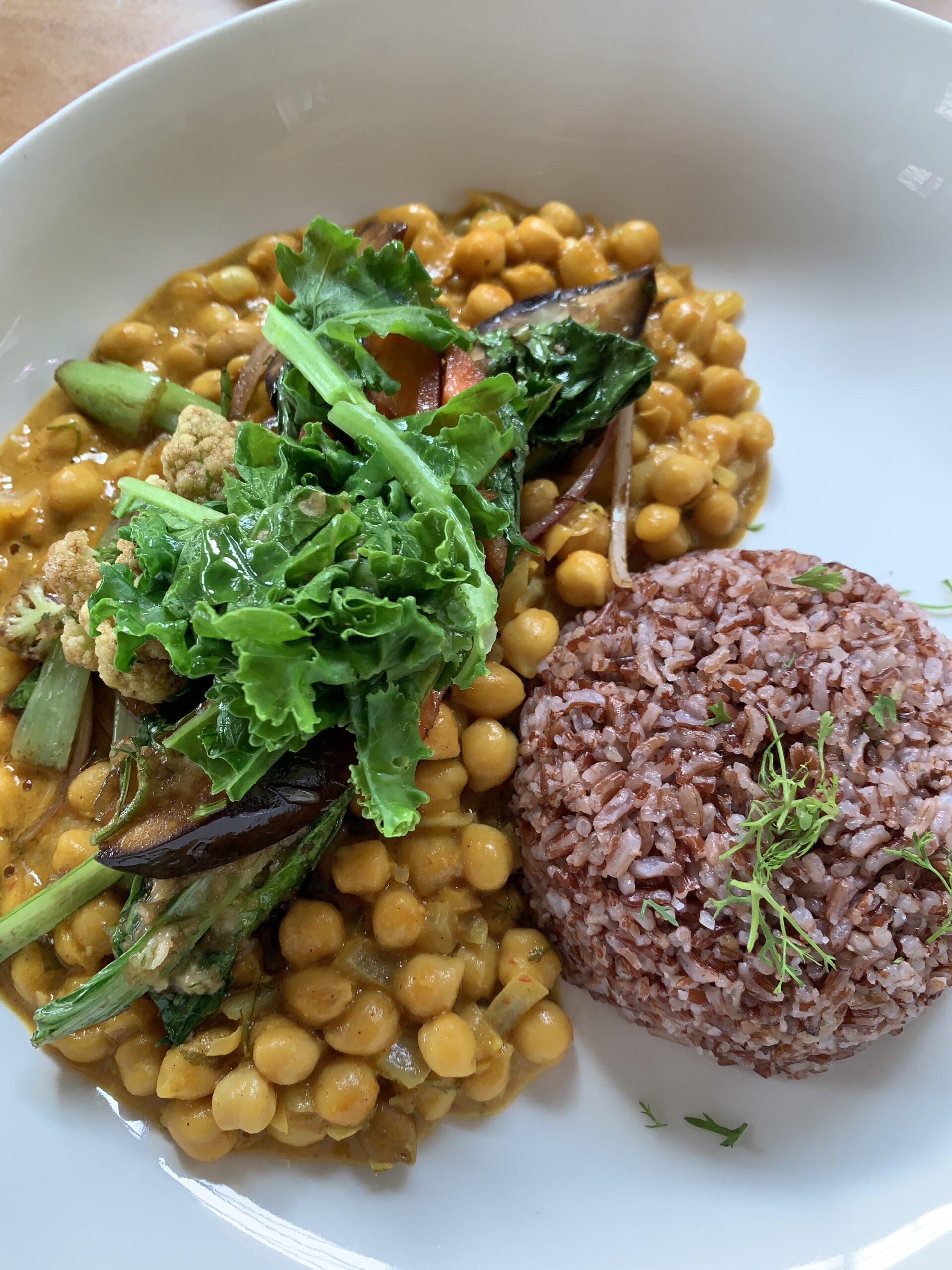 A plate of vegan chickpea curry with a side of brown rice from the Tatale Restaurant 