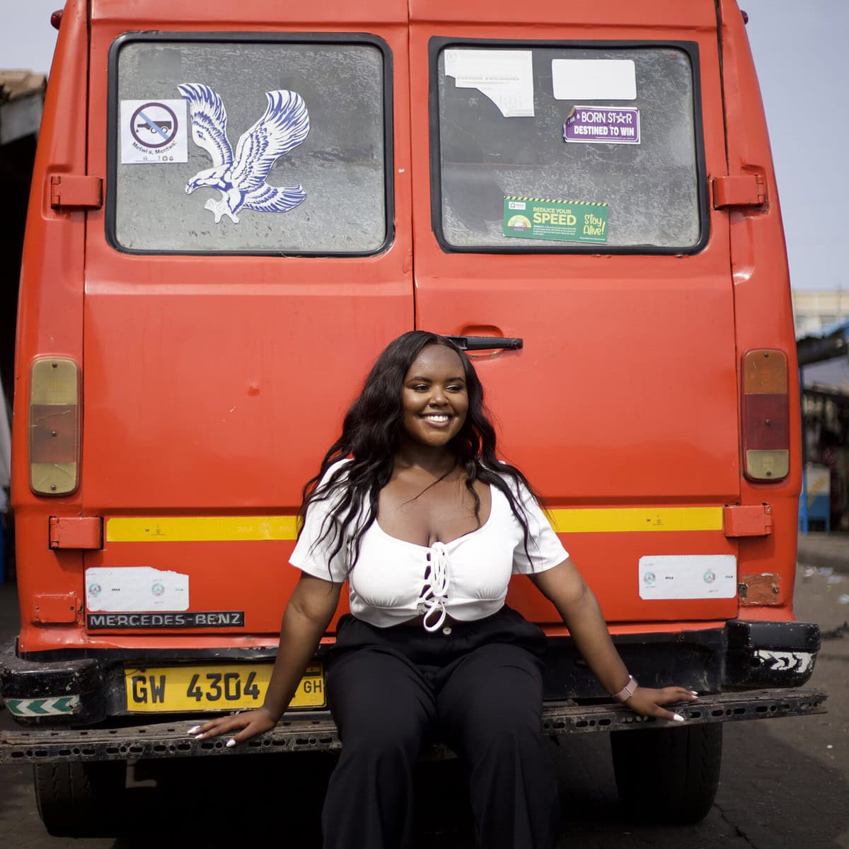 Blogger Christina Jane sitting on the back of a bright red tro-tro