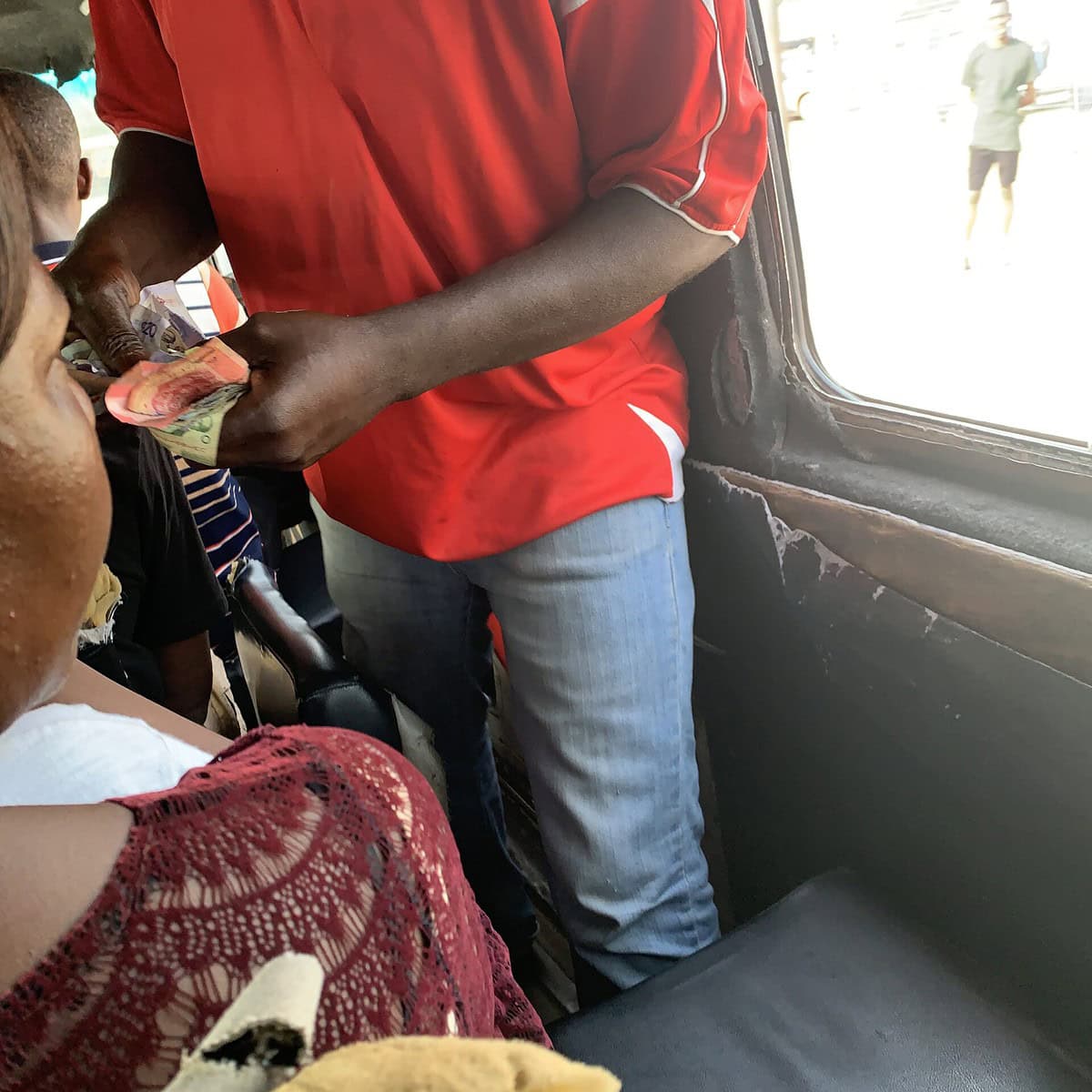 The mate on a tro-tro in Ghana handling cash. 