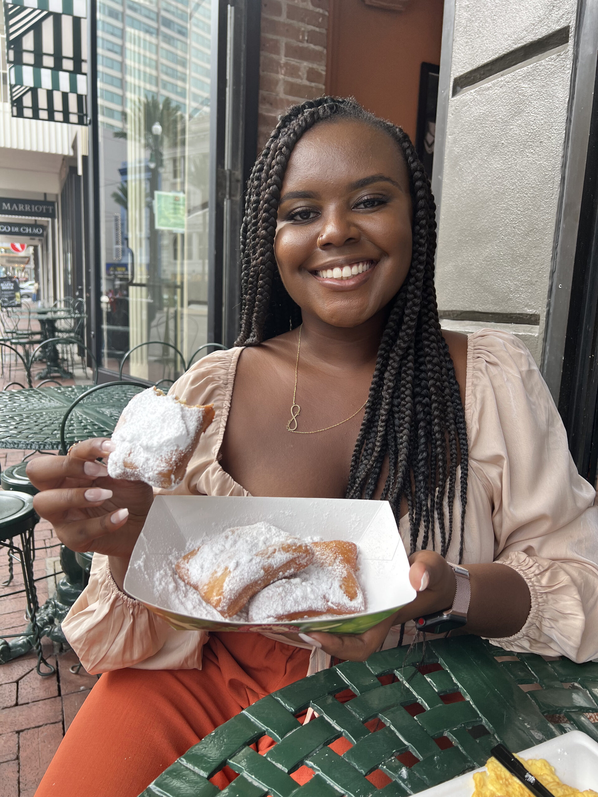 Christina Jane holding beignets from Cafe Beignets 