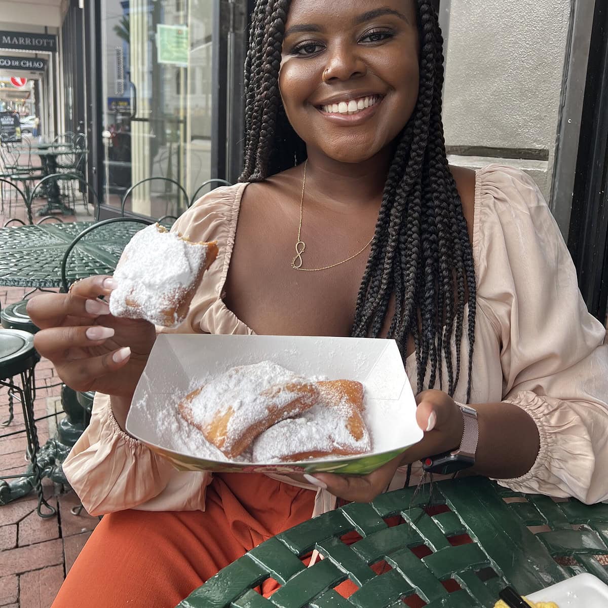 Christina Jane holding beignets from Cafe Beignets 