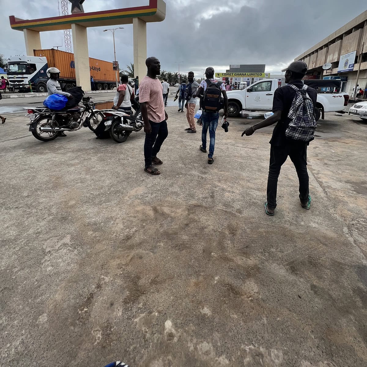 People surrounding the entrance of the Ghana Togo border. 