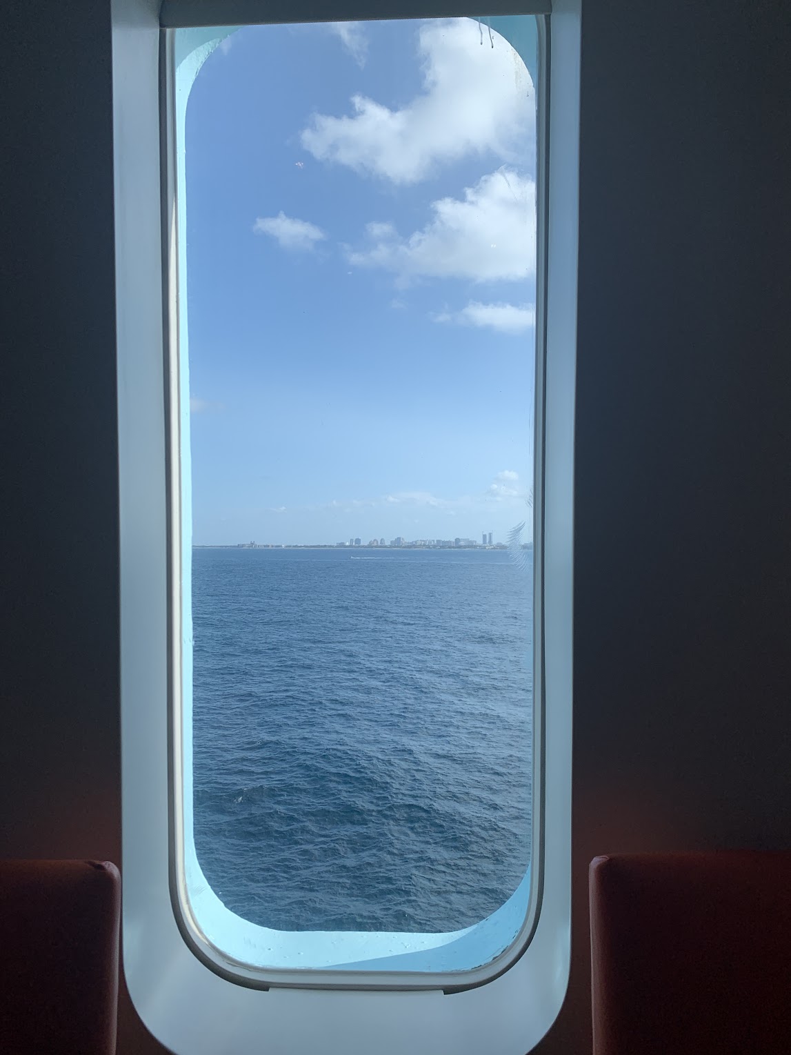 A window on a cruise ship showing the ocean.