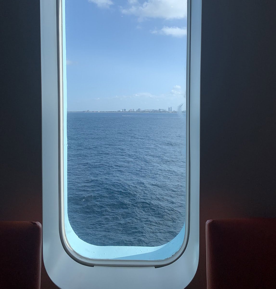 A window on a cruise ship showing the ocean.