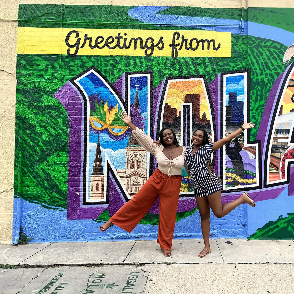 Christina Jane and her sister Jasmine posing in front of the 'Greetings from NOLA' sign. 