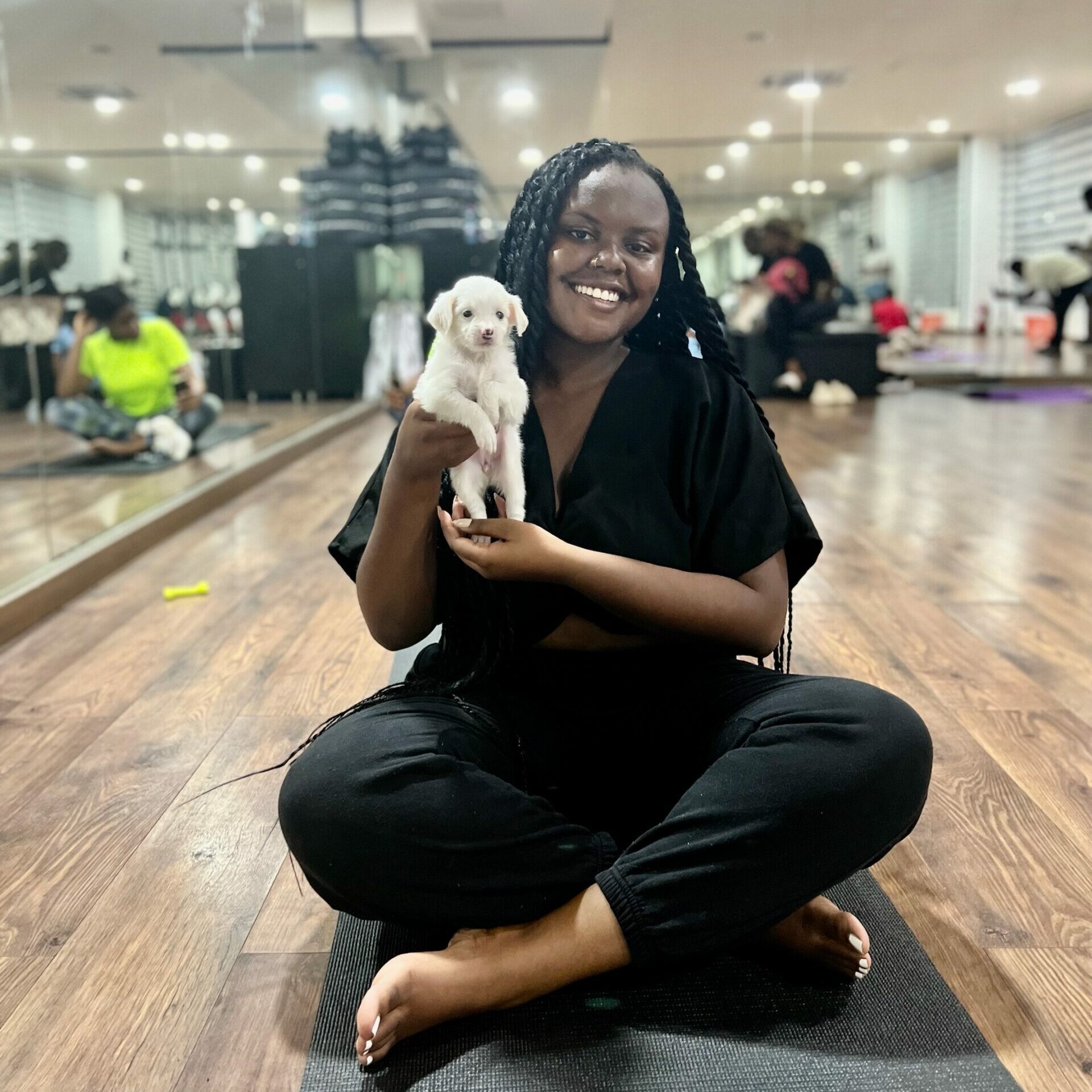 Christina holding a puppy at a puppy yoga class in Accra 