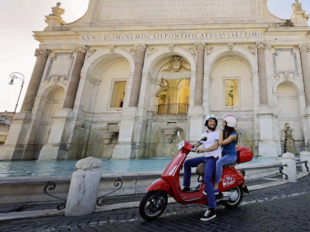 A couple enjoying a Vespa tour